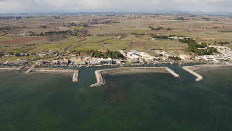 Small-fishing-port-of-Mazets-aerial-drone-shot-with-agriculture-fields-behind